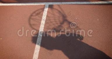 年轻漂亮的男篮球员的影子特写镜头，球场上有一个篮圈